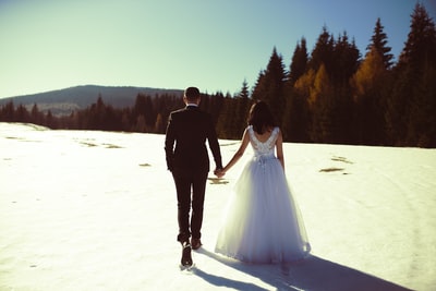 新郎和新娘走在雪地上
